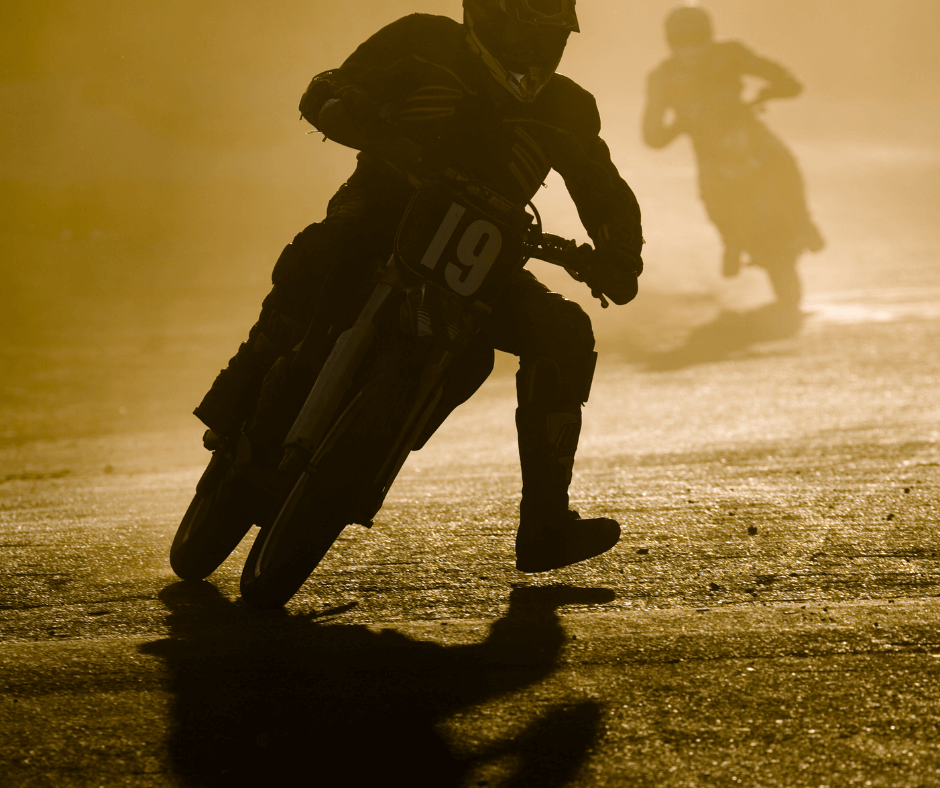 Off-road motorcycle riders riding through dust